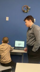 Ученик собирает робота по инструкции